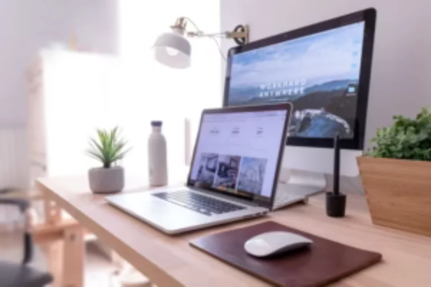 Modern workstation setup with a laptop and desktop computer showcasing creative website design layouts